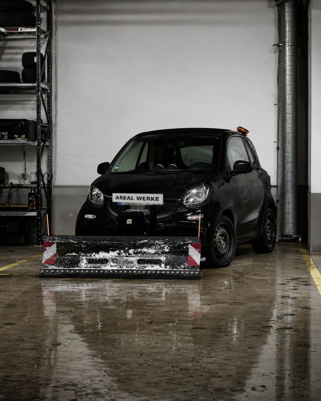 Räumfahrzeug mit montiertem Schneepflug in der Werkstatt, bereit für den Wintereinsatz